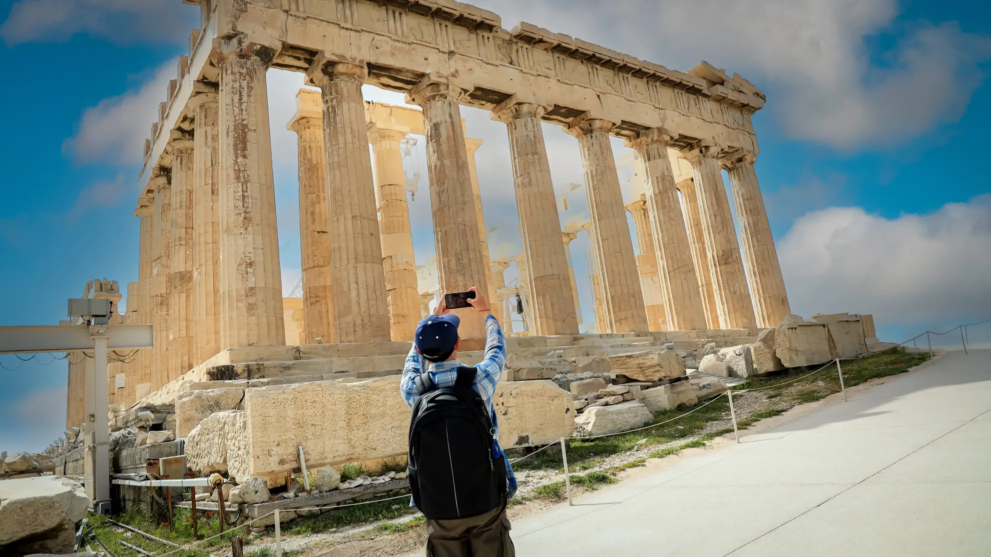 Solo traveller studying the Acropolis from the plateau with Athens spread out below