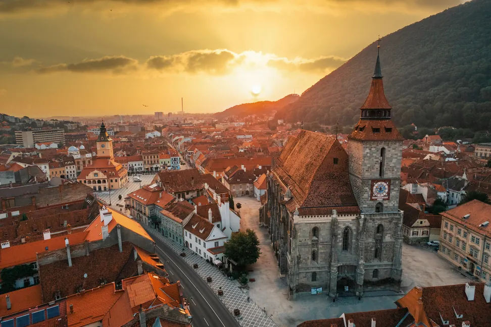 La Iglesia Negra sobre los tejados del casco antiguo de Brașov al atardecer