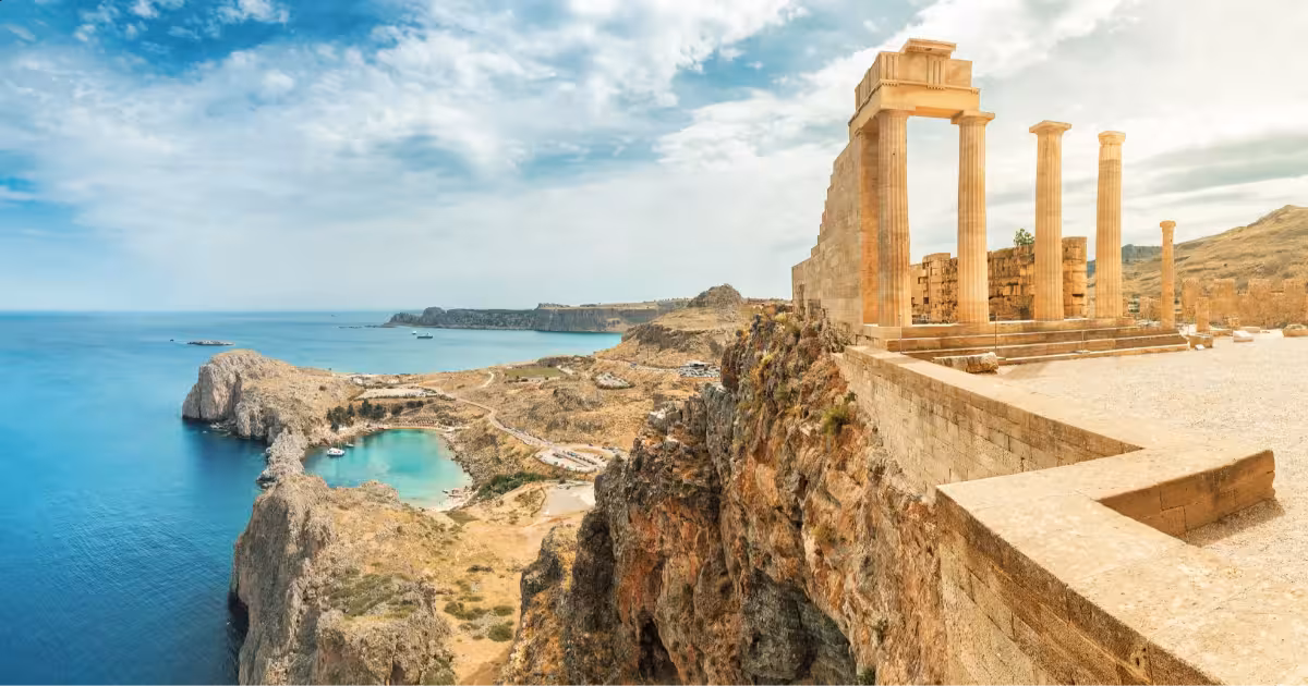 Ancient stone temples and blue Mediterranean waters in Greek island landscape.
