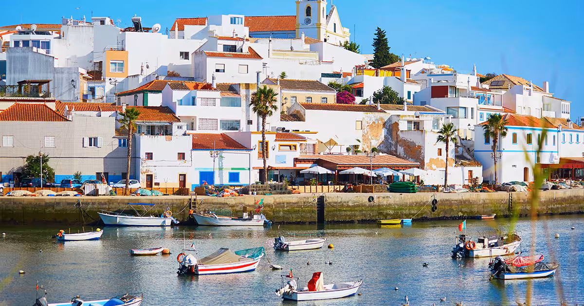 Case imbiancate e barche da pesca lungo il lungofiume Arade di Ferragudo.