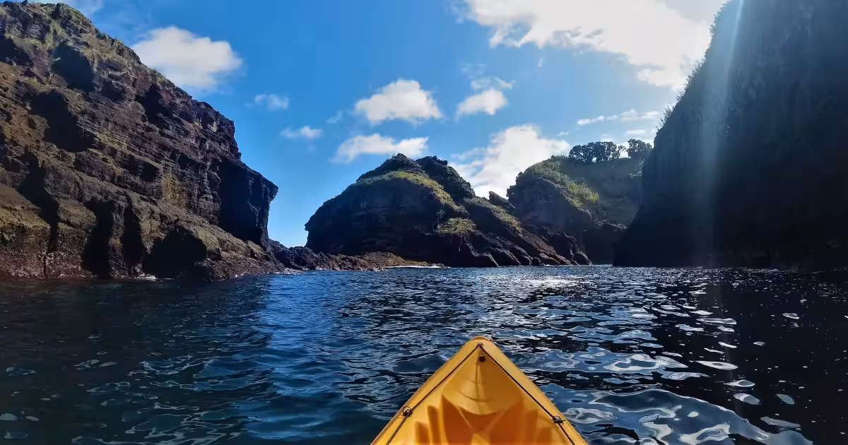 Kayaker paddling inside the circular crater of Vila Franca do Campo islet, Azores.