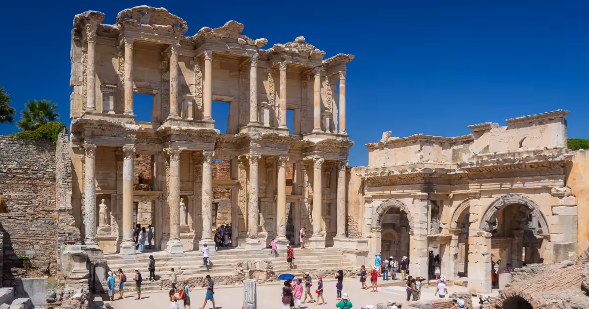 Ancient marble columns and archways of Ephesus ruins in afternoon light.