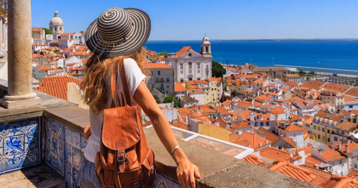 Panoramic view of Alfama rooftops and Tagus River from a Lisbon miradouro.