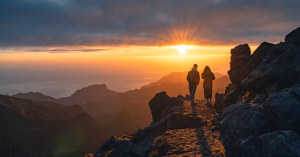 Golden sunrise light over volcanic peaks of Pico do Areeiro above the clouds.