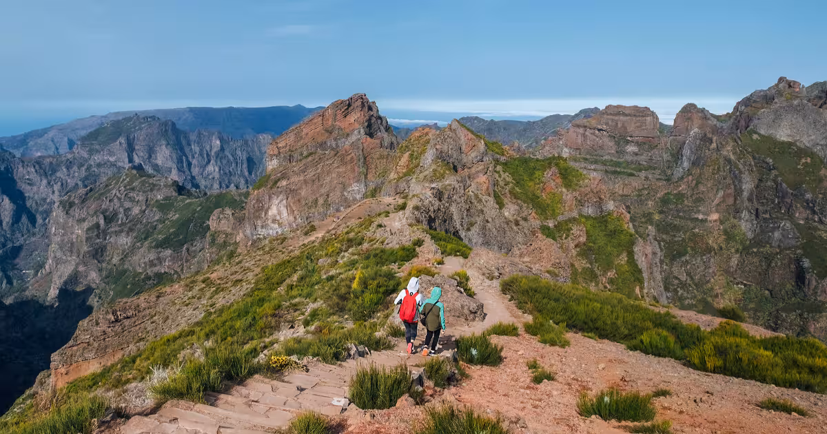 Hiker on rocky ridge between Pico do Areeiro and Pico Ruivo at sunrise, Madeira.