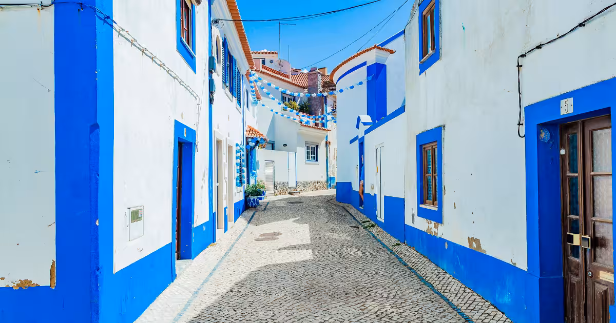 Narrow whitewashed lane in a Portuguese hilltop village at golden hour