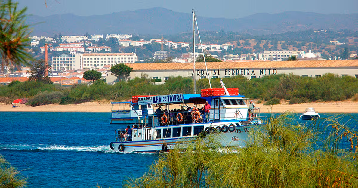 Barca in legno che attraversa la laguna della Ria Formosa verso Ilha de Tavira, Algarve.