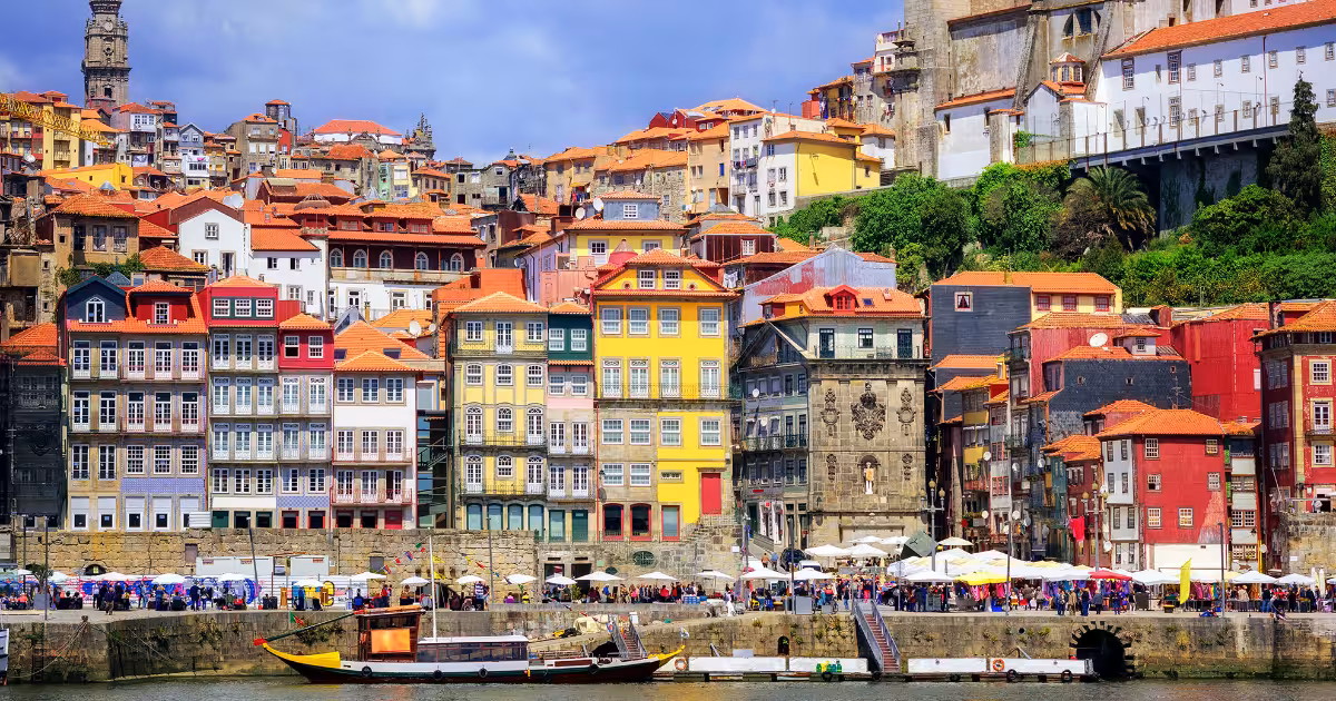Porto Ribeira waterfront at golden hour with Dom Lu&iacute;s I Bridge in background