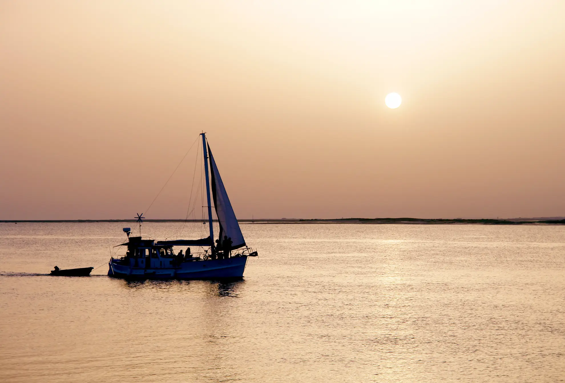 Sunset over Ria Formosa Natural Park lagoon from a tour boat near Faro.