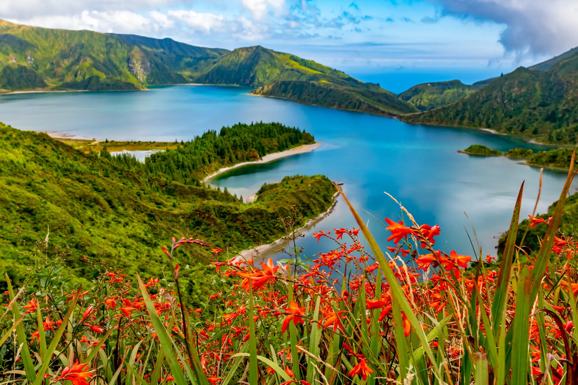 Lagoa do Fogo crater lake surrounded by bare volcanic cliffs and Azorean heathland.