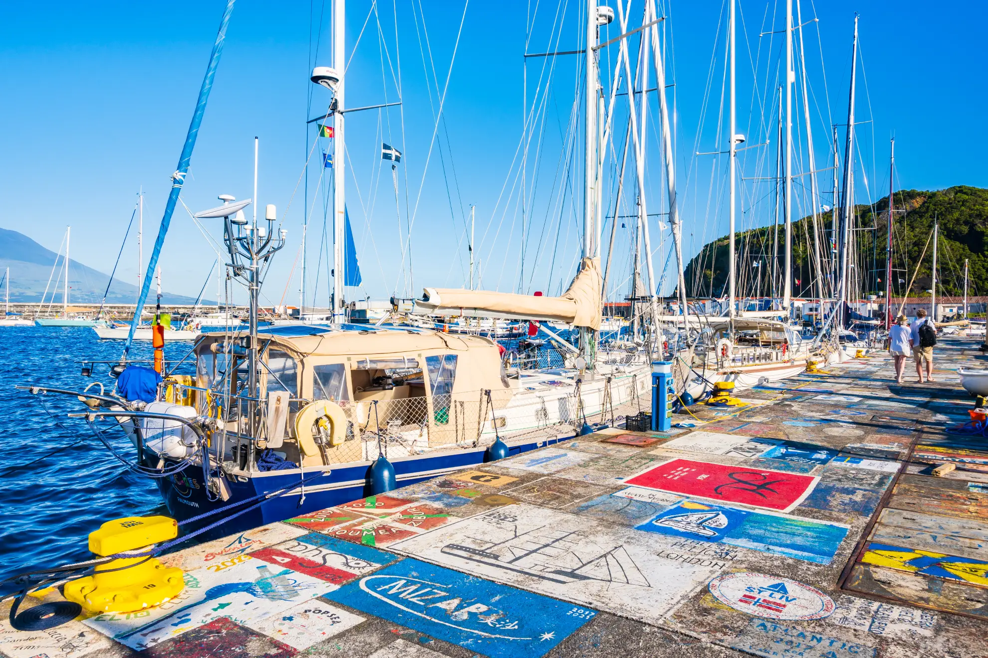 Horta marina on Faial Island with iconic painted boat murals on harbour wall.