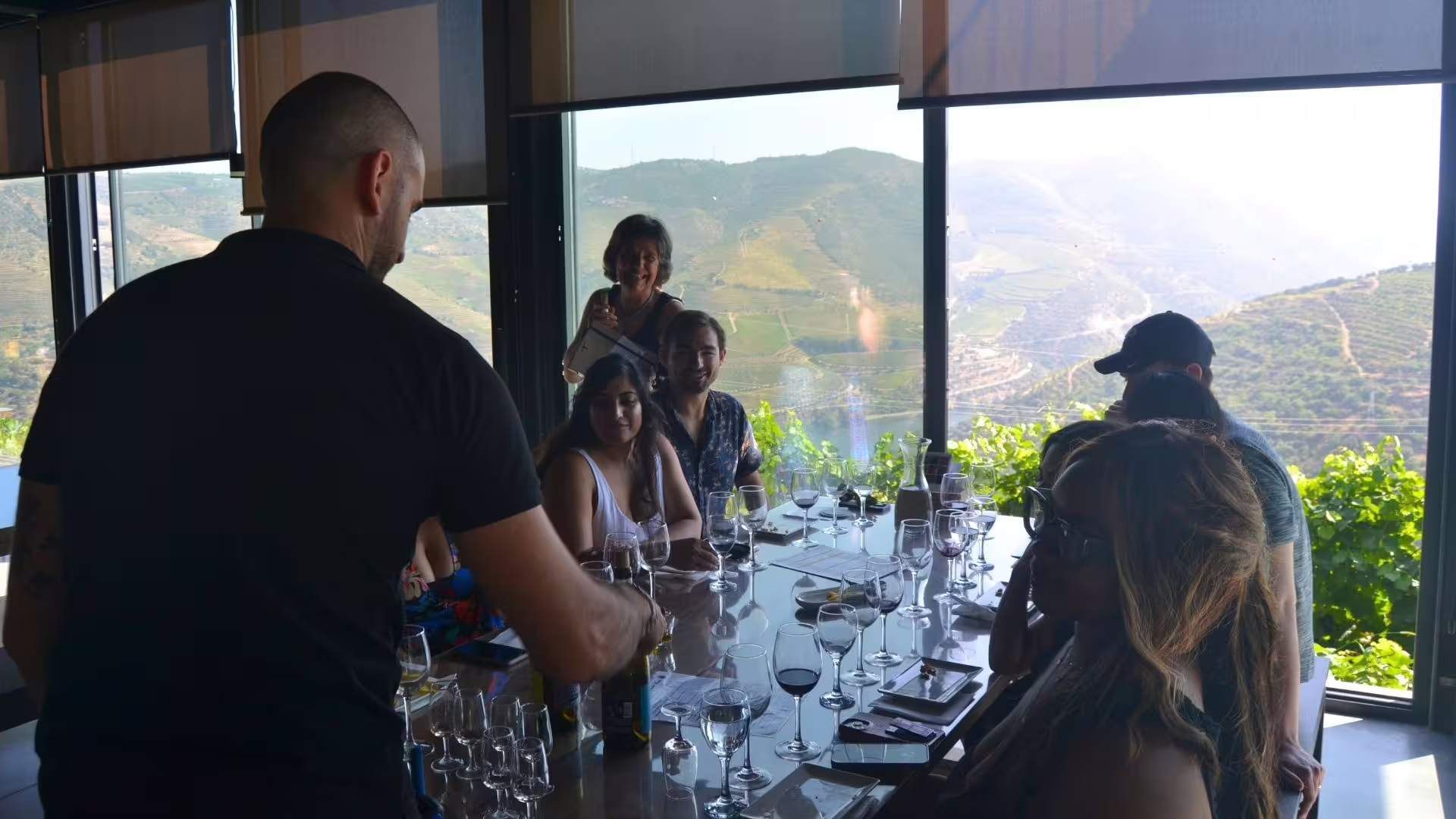 Visitors tasting wine with a winemaker inside a Douro Valley quinta cellar in winter.
