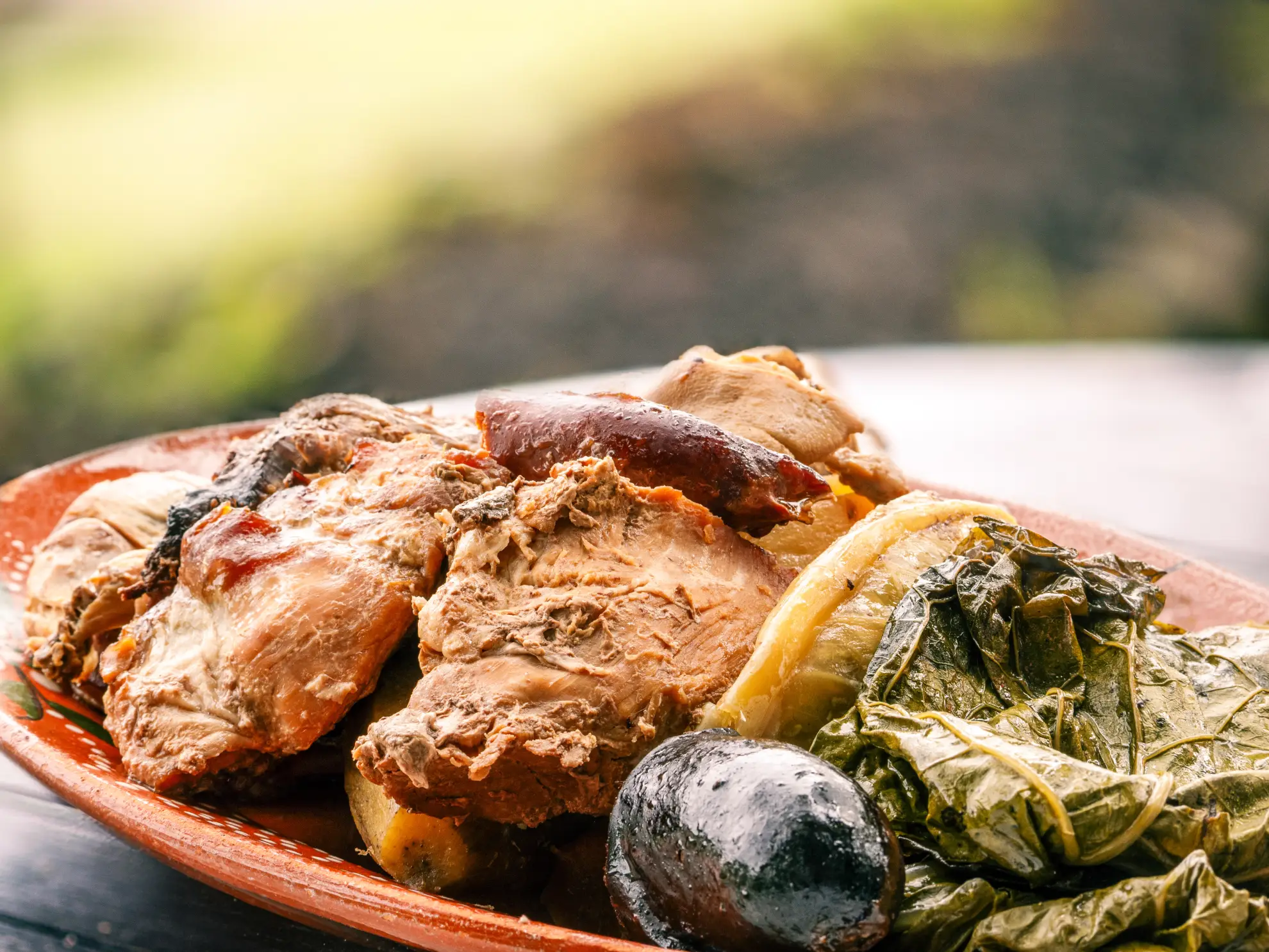 Traditional Cozido das Furnas served in a ceramic bowl with layered meats and root vegetables.