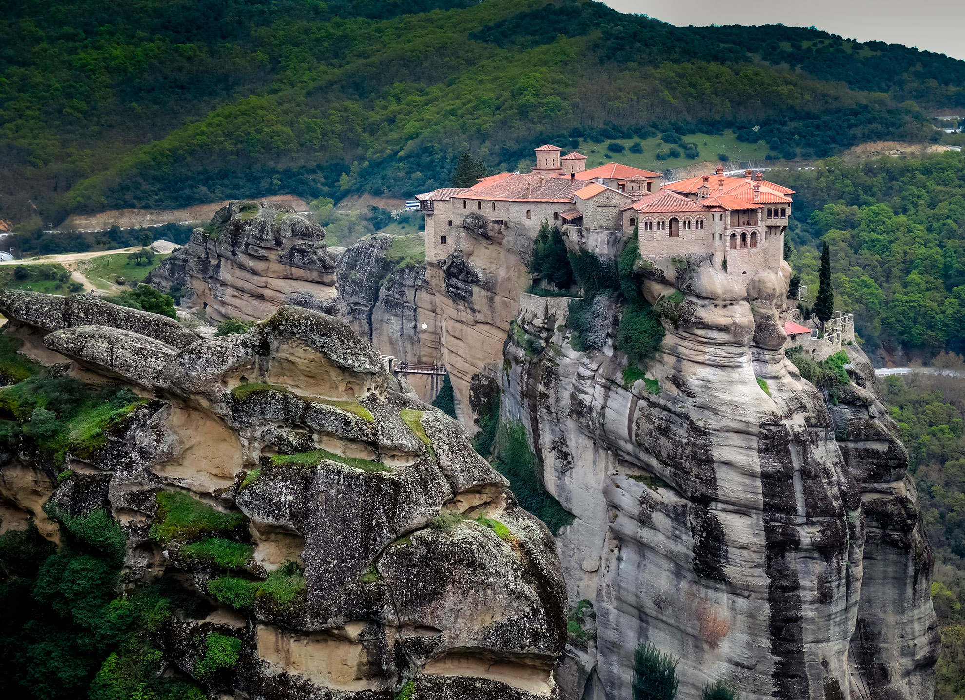 A Meteora monastery sitting atop a dramatic vertical rock formation in central Greece.