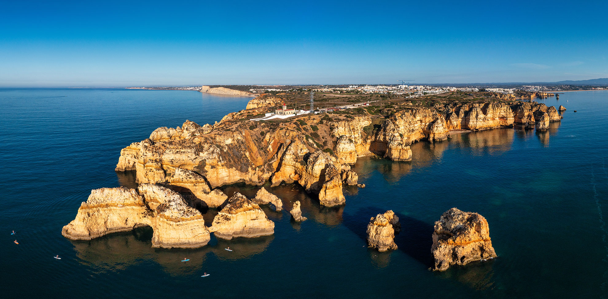 Catamaran passing beneath the limestone sea stacks of Ponta da Piedade near Lagos.