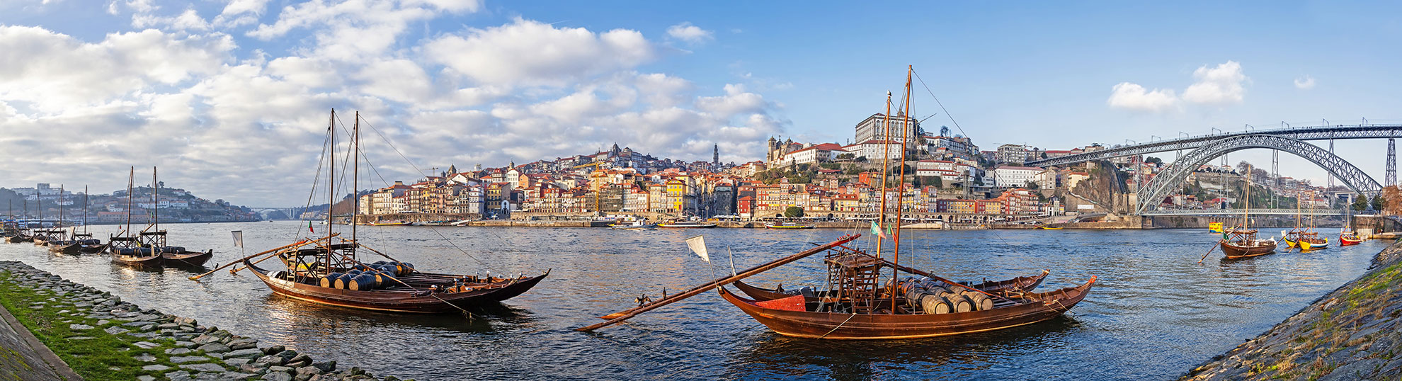 Traditional Rabelo boat on the Douro River beneath the Dom Lu&iacute;s I Bridge.