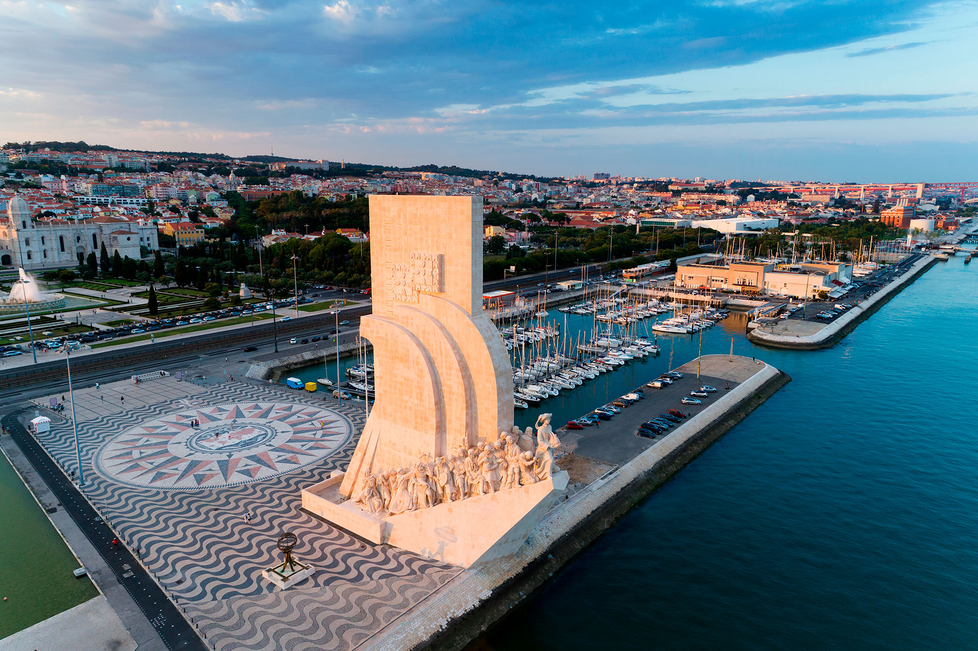 Bel&eacute;m waterfront promenade with the 25 de Abril Bridge in the background at sunset.