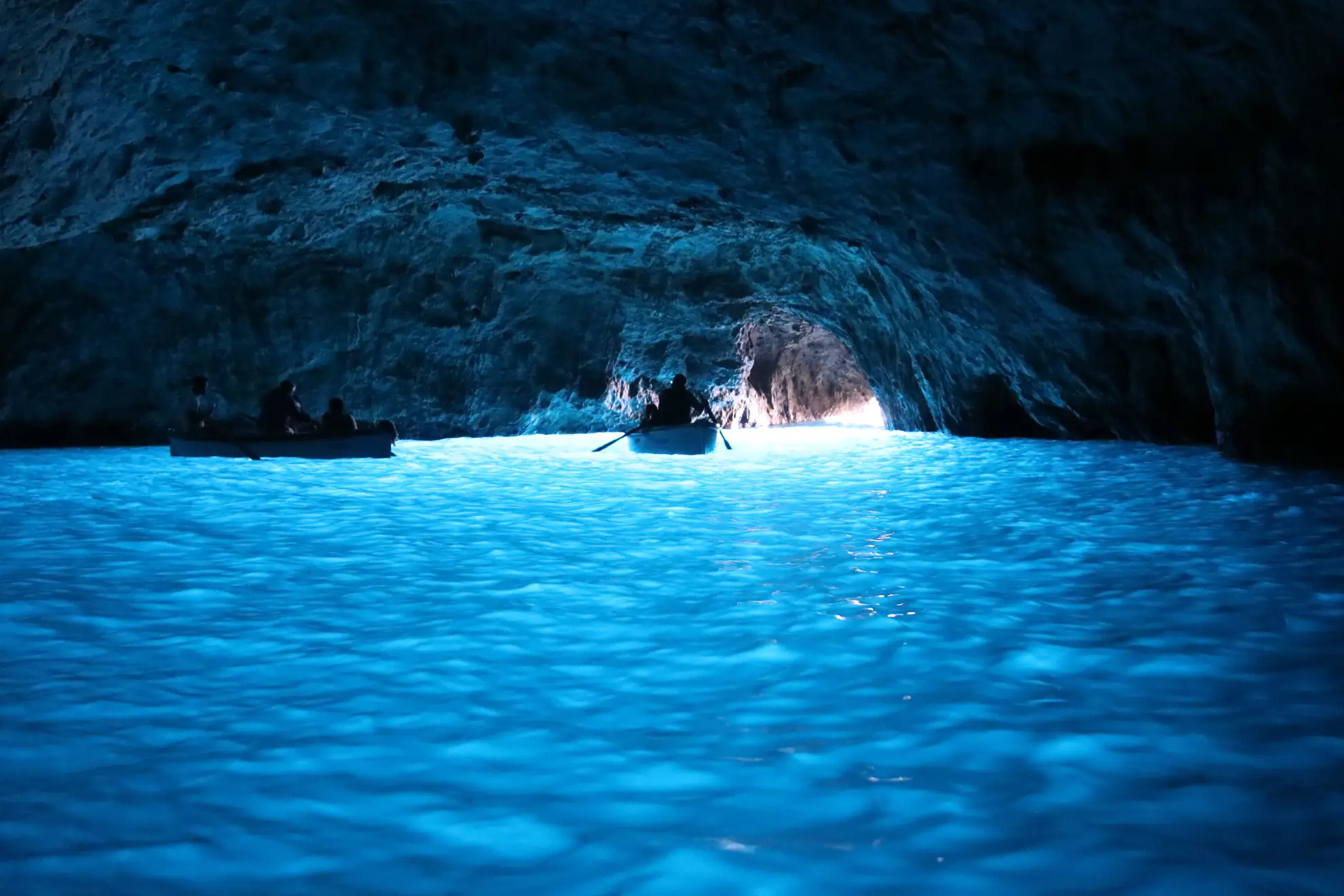 Blue Grotto entrance at Capri showing turquoise water illuminated by refracted sunlight.
