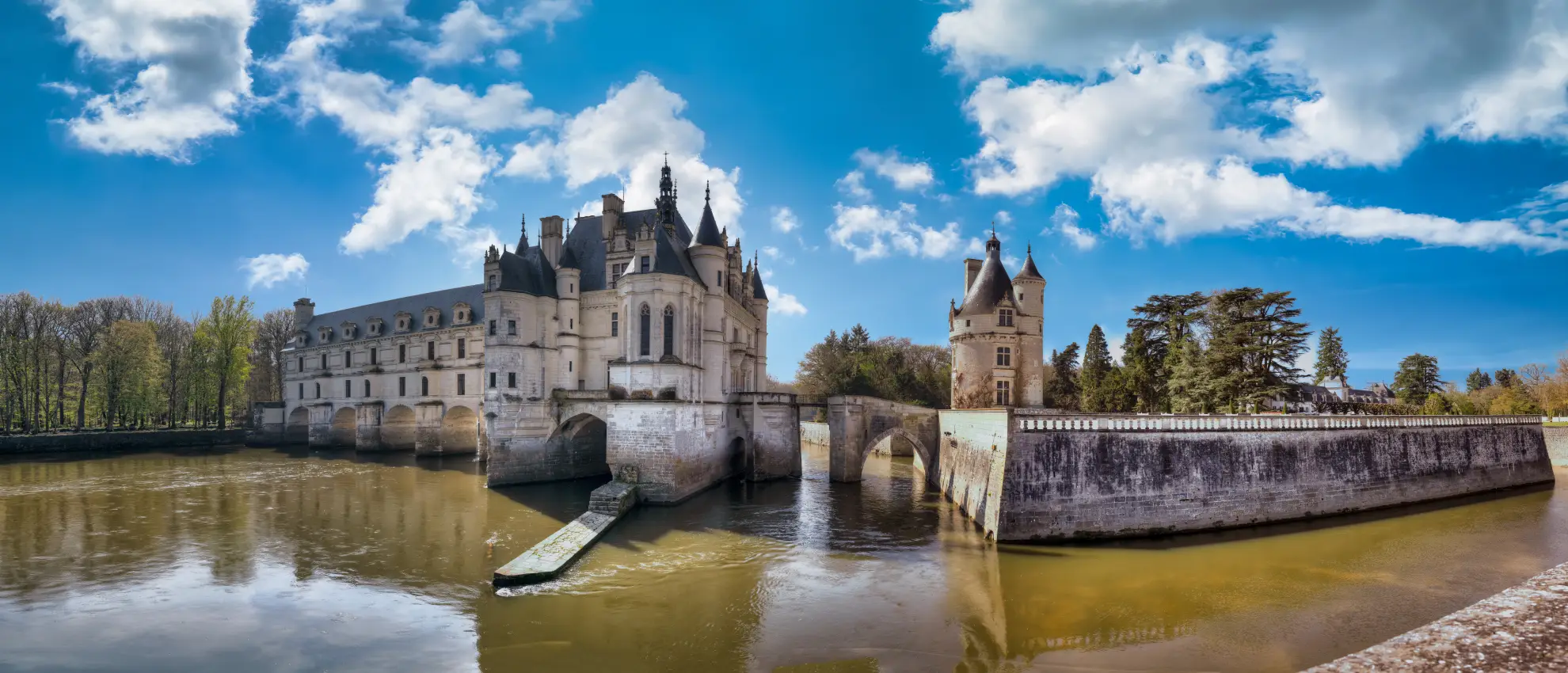 Ch&acirc;teau de Chenonceau bridge spanning the River Cher in dappled sunlight.
