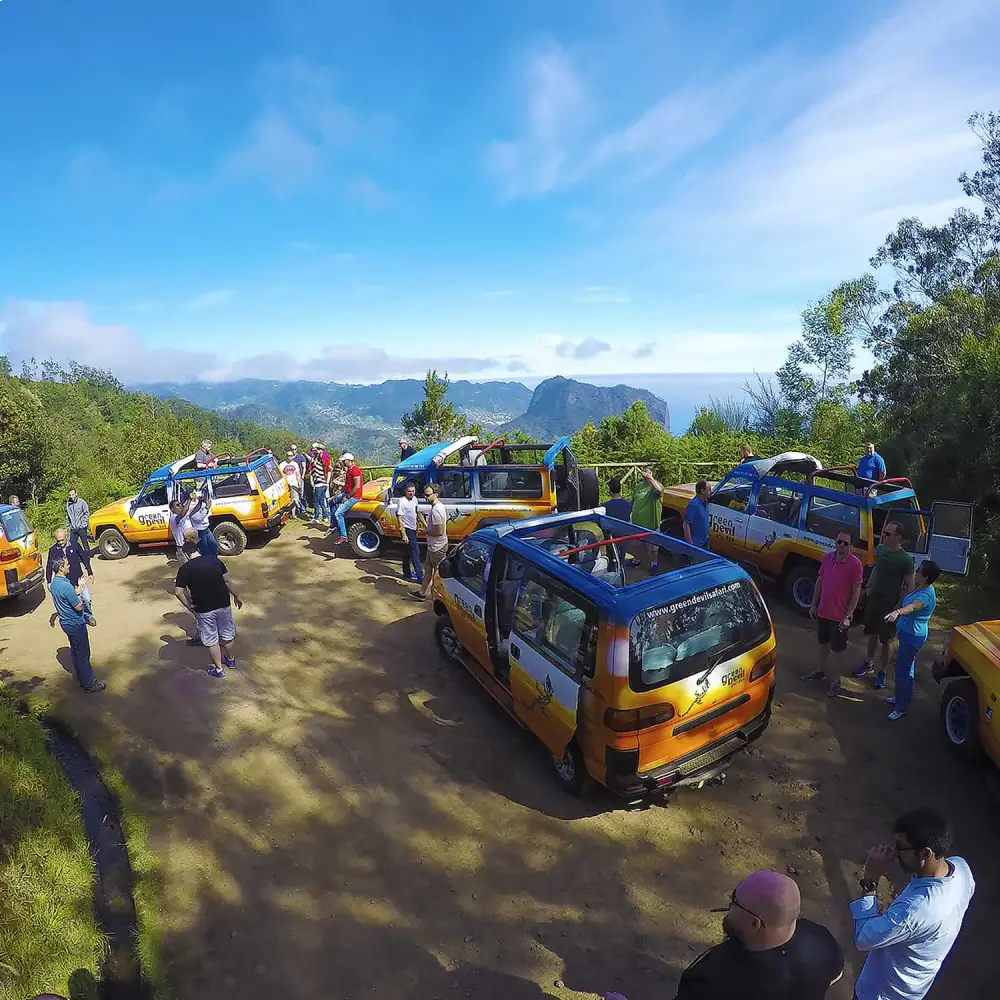 Passengers standing in open-roof 4x4 jeep above Santana valley, northeast Madeira.