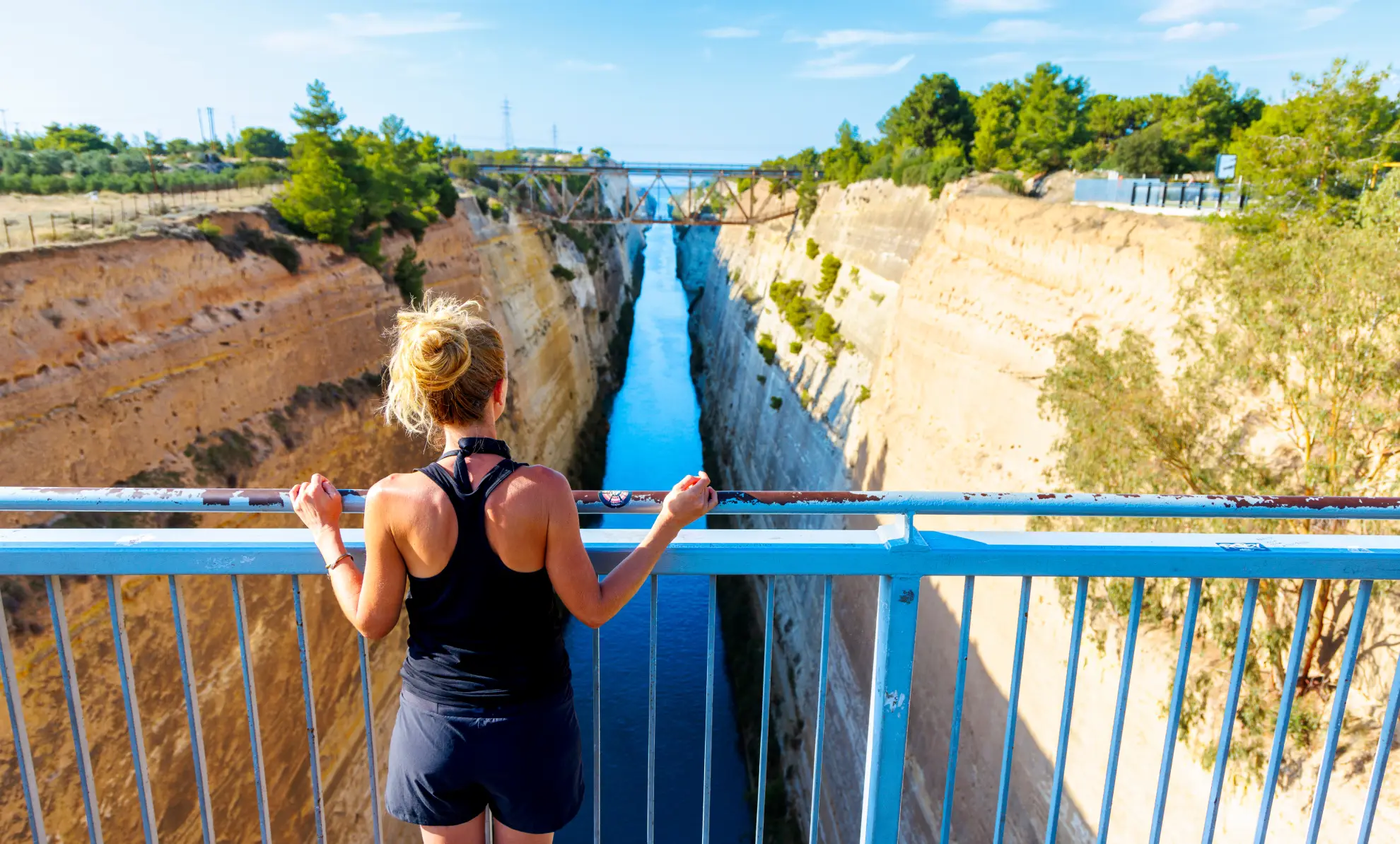 Corinth Canal cutting through dramatic limestone cliffs, narrow passage between high canyon walls.