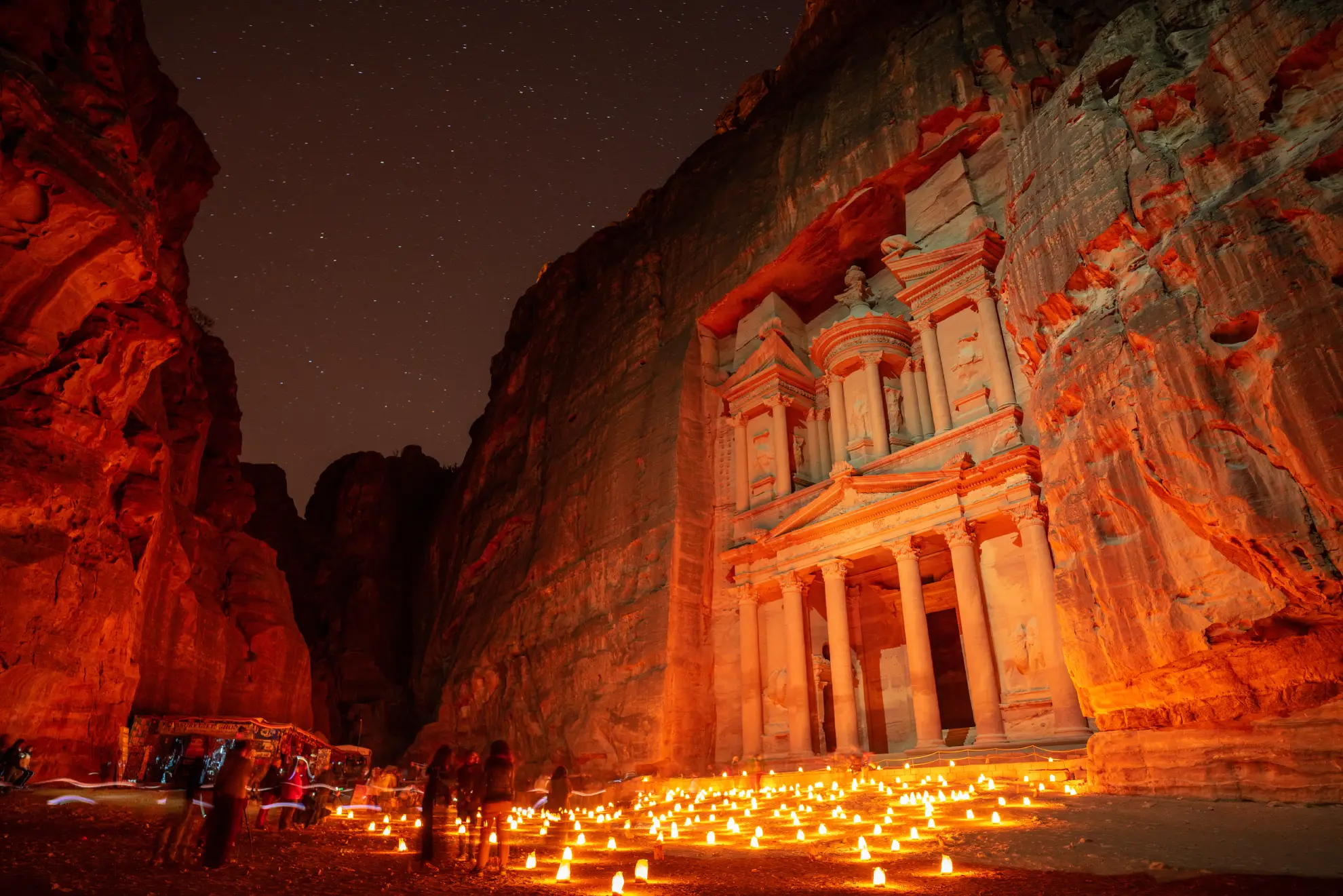 Candlelit Siq pathway during Petra by Night experience with warm amber glow.