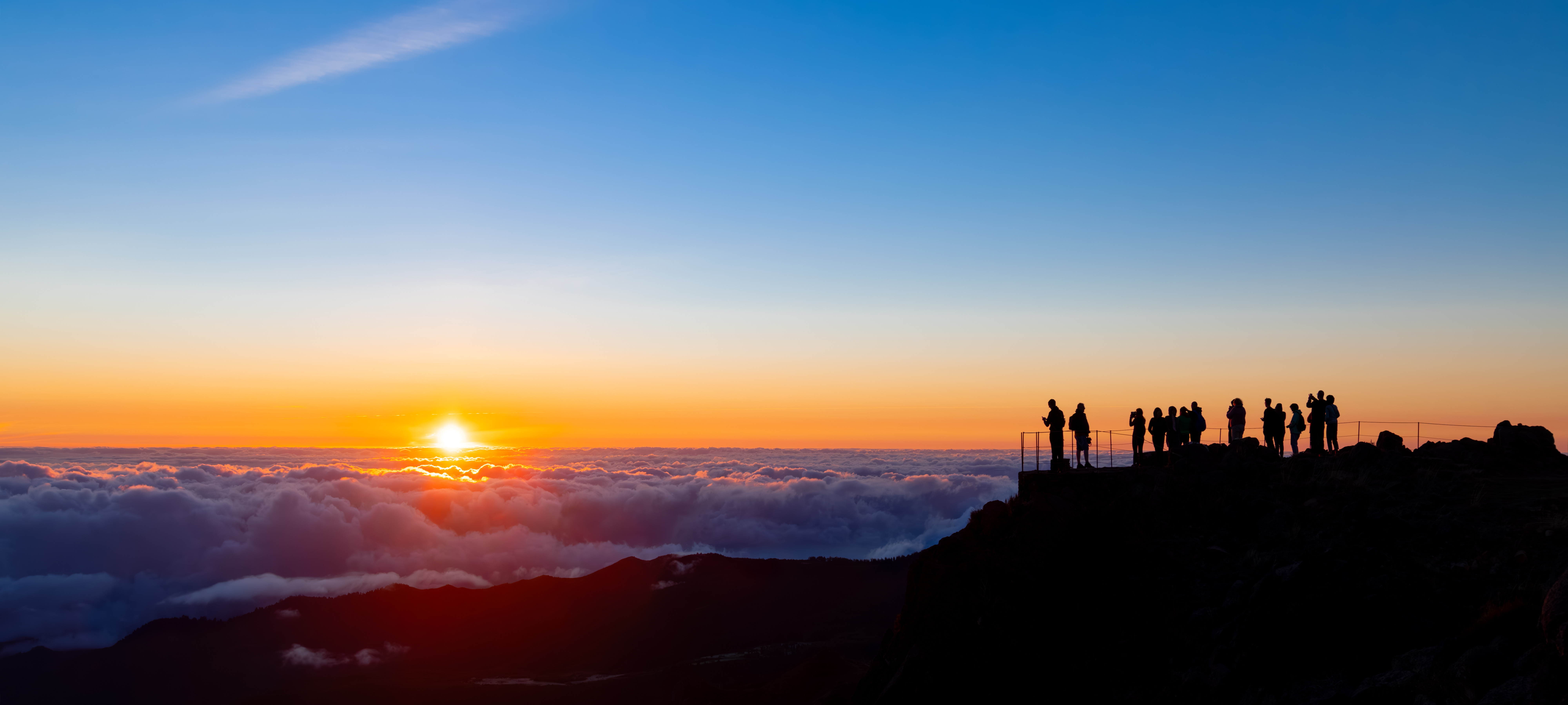 Panoramic sunrise view from Pico Ruivo summit above cloud sea in Madeira.