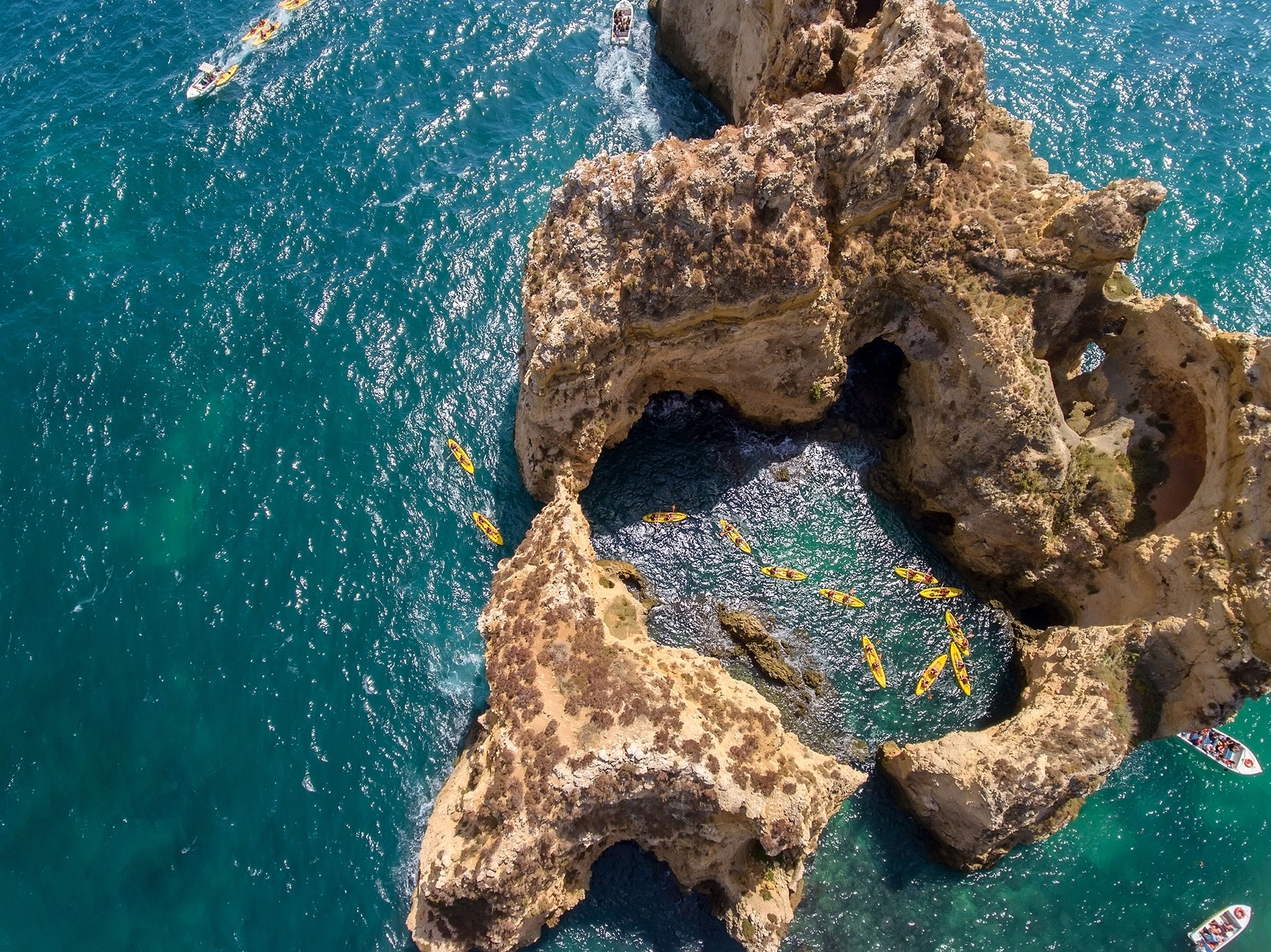 Aerial view of kayakers paddling between sea stacks at Ponta da Piedade Lagos