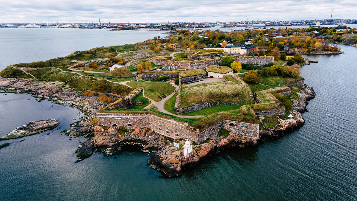 A breathtaking aerial view of Suomenlinna Fortress, showcasing its fortifications, lush greenery, and surrounding sea.