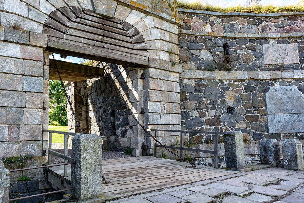 The historic King’s Gate of Suomenlinna, standing tall with its stone archway and scenic coastal backdrop.